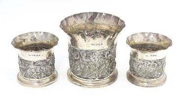 Three Victorian silver bottle coasters with floral scroll and bird detail and flared rims,