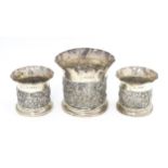 Three Victorian silver bottle coasters with floral scroll and bird detail and flared rims,