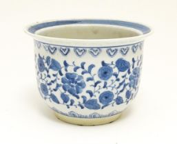 A Chinese blue and white planter / jardiniere decorated with scrolling flowers and foliage.