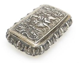 A white metal snuff box decorated with various deities, including one to centre depicting a deity