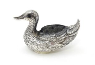 A silver pin cushion formed as a duck. Approx. 2" long Please Note - we do not make reference to the