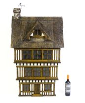 A 20thC Robert Stubbs Tudor style dolls house with timbered exterior and moulded thatched roof
