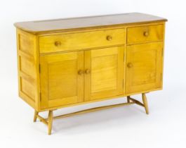 Vintage / Retro: An Ercol elm sideboard, model 351. The figured elm top above a single long