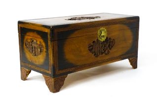 An early 20thC oriental camphor wood trunk with sides, lid and front, depicting figures within a