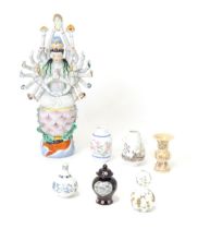A Chinese ceramic model of Guanyin with 24 arms holding various symbols to include ruyi, flowers,