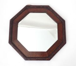 An octagonal mirror within an oak frame with foliate border. Approx. 19 1/4" high Please Note - we