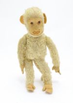 Toy: A 20thC mohair soft toy modelled as a monkey / chimpanzee, with a wired tail and felt face,