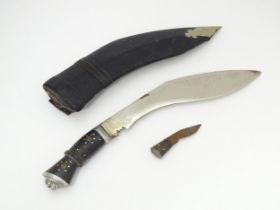 A mid 20thC Indian kukri knife, with 12" polished steel blade, carved wooden hilt and leather sheath