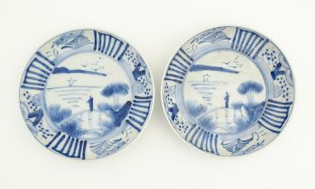 A pair of Oriental blue and white dishes each depicting a figure on a bridge looking out to sea with