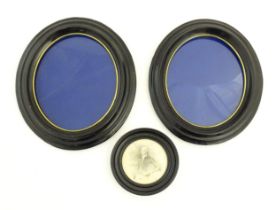 A pair of early 20thC ebonised frames of oval form. Together with a ebonised frame of circular form.