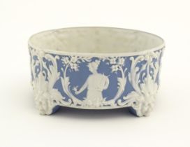 A blue and white Jasperware style plant stand with relief Pan detail and scrolling foliage.