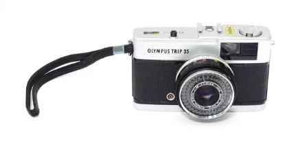 An Olympus Trip 35 compact 35mm film camera with wrist strap. Please Note - we do not make reference