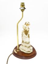 A Leonardo figural table lamp, the mahogany oval stand with brass upstand and lady in Edwardian