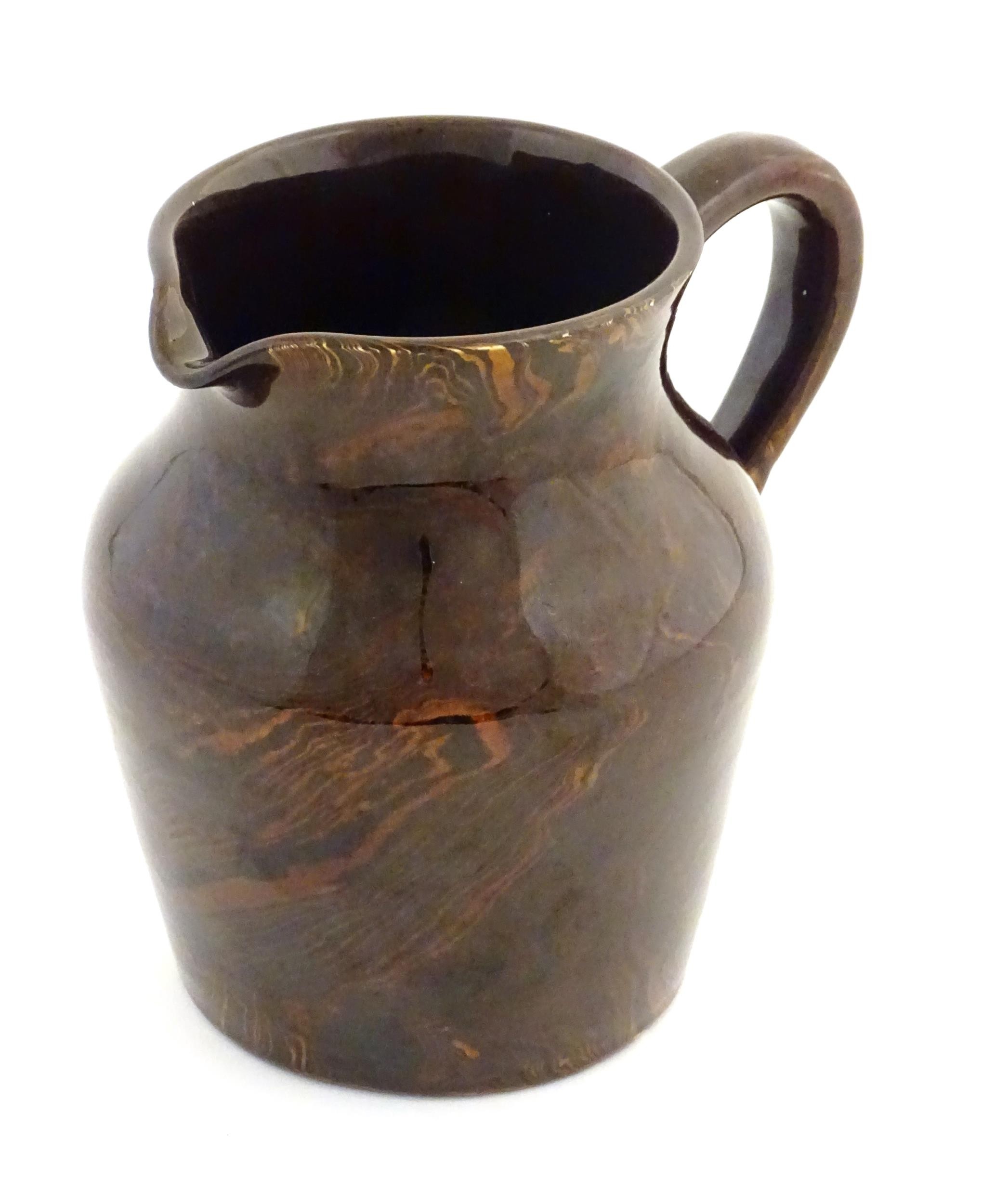 An agate wear jug with loop handle. Approx. 4 1/2" high Please Note - we do not make reference to