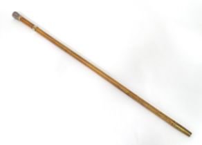 An early 20thC malacca walking cane, with a gilt band formed as a belt and a white metal knop