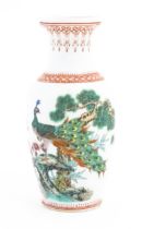 A Chinese vase decorated with a peacock perched on a branch with flowers and foliage. Marked