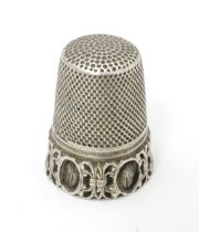 A white metal thimble. Approx. 1" high Please Note - we do not make reference to the condition of