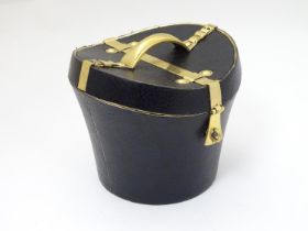 A 21stC novelty brass caddy / container formed as a saddle shaped hat box with black leather