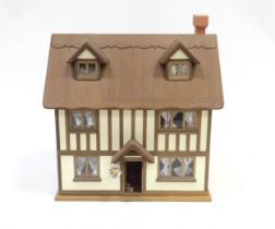 A mid 20thC dolls house, the front and roof opening to reveal six rooms containing assorted dolls