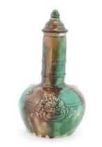 A majolica bottle vase and cover with relief decoration depicting the snuff taker. Approx. 10"