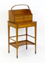 A 19thC satinwood Bonheur du jour, the removeable top having an arched carrying handle and three