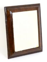 A late 18thC / early 19thC cushion mirror with a moulded walnut frame. 22" wide x 25" high. Please