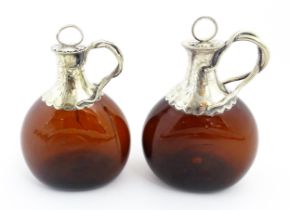 Two Victorian whiskey flasks / spirit flagons, the brown amber glass bottles with silver plate