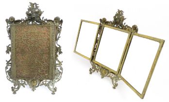 A Victorian brass and copper easel back triptych mirror with floral, foliate, cherub and