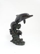 A bronze sculpture / water feature modelled as three dolphins leaping from a wave. Approx. 16 1/4"