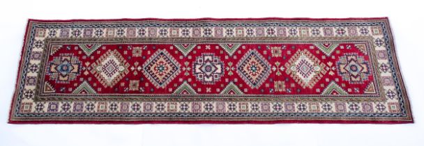 Carpet / Rug : A Turkish Kazak runner with red ground decorated with repeating geometric motifs