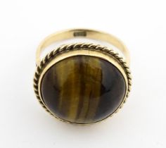 A 9ct gold ring set with central tigers eye cabochon. Ring size approx. O 1/2 Please Note - we do