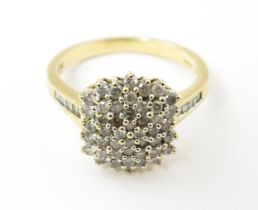 A 9ct gold ring set with a profusion of diamonds with further diamonds to shoulders. Ring size