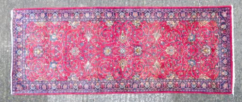 Carpet / Rug : A Persian Sarouk runner, the red ground with scrolling floral and foliate detail