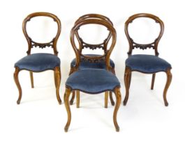 A set of four 19thC walnut dining chair with balloon backs and carved pierced mid rails, the