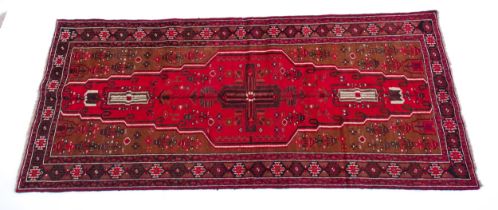 Carpet / Rug : A Persian Meshed Belouch rug with red ground decorated with floral and geometric