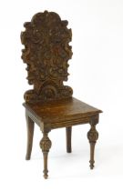 A 19thC carved oak hall chair, with an acanthus and scrolled backrest above a fluted front rail