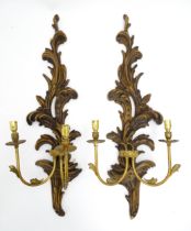 A pair of carved wooden wall lights with acanthus scroll detail, with gilt metal twin branches.