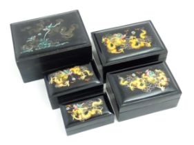 A set of four Oriental graduated boxes of rectangular form with hand painted dragon and flaming