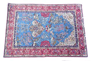 Carpet / Rug : A blue ground rug decorated with trees in blossom, floral and scroll detail, with