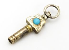 A gilt metal pocket watch key set with turquoise cabochon. Approx. 1" long Please Note - we do not