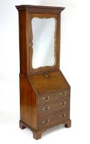 A mid 18thC mahogany bureau bookcase with a moulded cornice above a dentil frieze and shaped