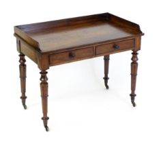 A William IV mahogany writing table with a shaped upstand above two short drawers and raised on