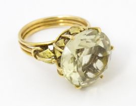 A yellow metal ring set with central citrine with foliate detail to mount. Ring size approx. N