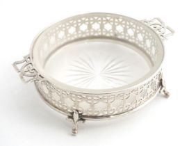 A silver butter / preserve dish with twin handles and glass liner, The frame with geometric openwork