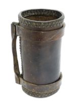 A late 19thC cordite carrier, constructed from leather with vertical strap and riveted seams, the