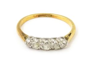 An 18ct gold ring with five platinum set diamonds. Ring size approx. L Please Note - we do not
