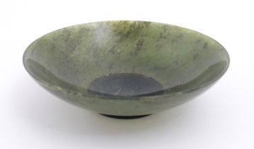 An Oriental carved jade coloured hardstone dish. Approx. 3" diameter Please Note - we do not make