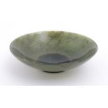 An Oriental carved jade coloured hardstone dish. Approx. 3" diameter Please Note - we do not make