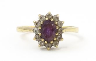 A 9ct gold ring set with central amethyst bordered by white stones. Ring size approx. N Please