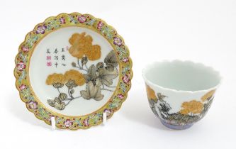 A Chinese dish with scalloped edge decorated with flowers, foliage and Character script, with a